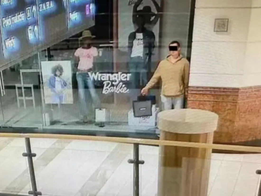 Le Voleur immobile (en beige) dans la vitrine d'un magasin de vêtements