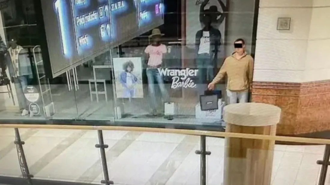 Le Voleur immobile (en beige) dans la vitrine d'un magasin de vêtements