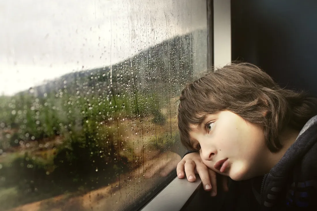 Un enfant regardant la pluie