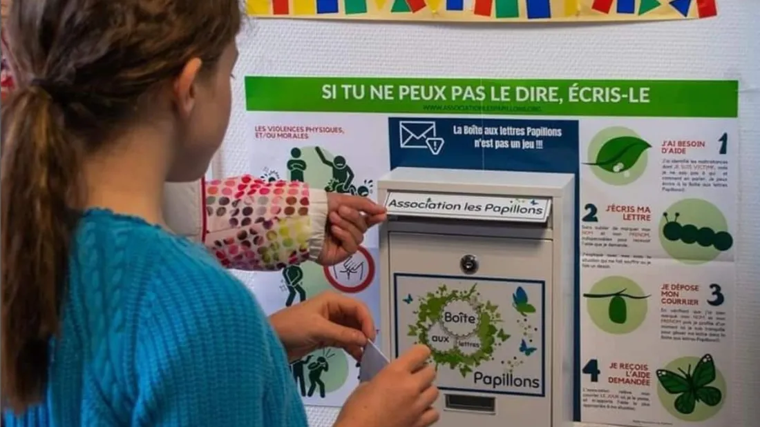 Une jeune fille devant la boîte aux lettres "Papillons" 