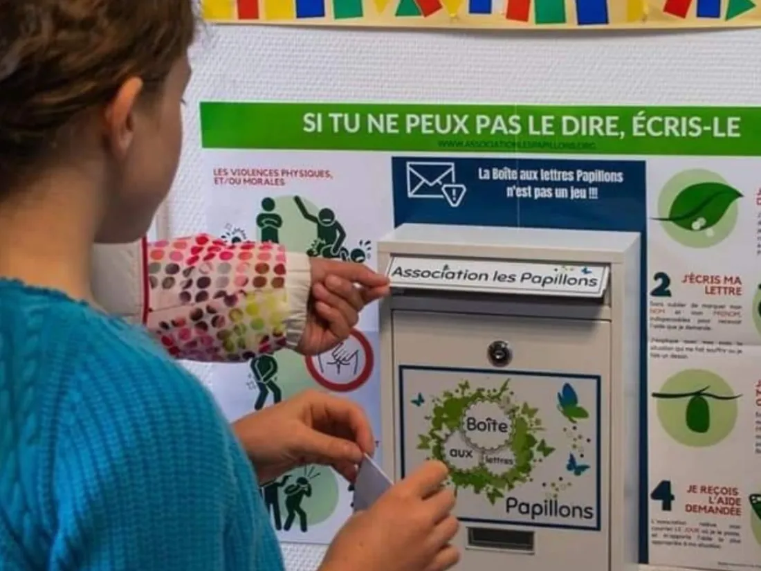 Une jeune fille devant la boîte aux lettres "Papillons" 