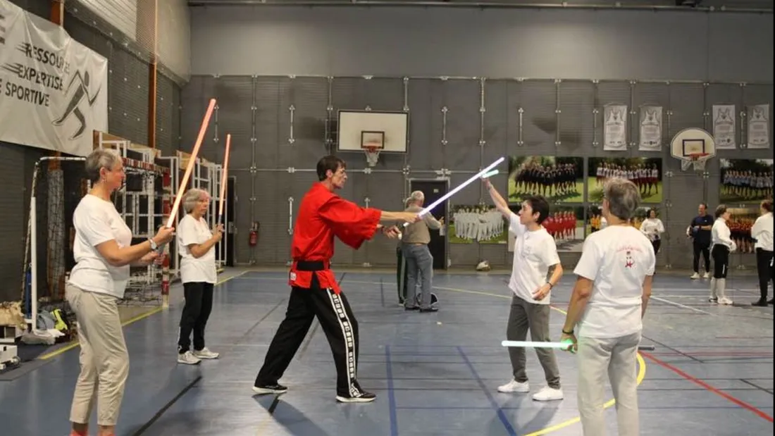 Un maître d'arme en plein cours de sabre laser avec des patientes 