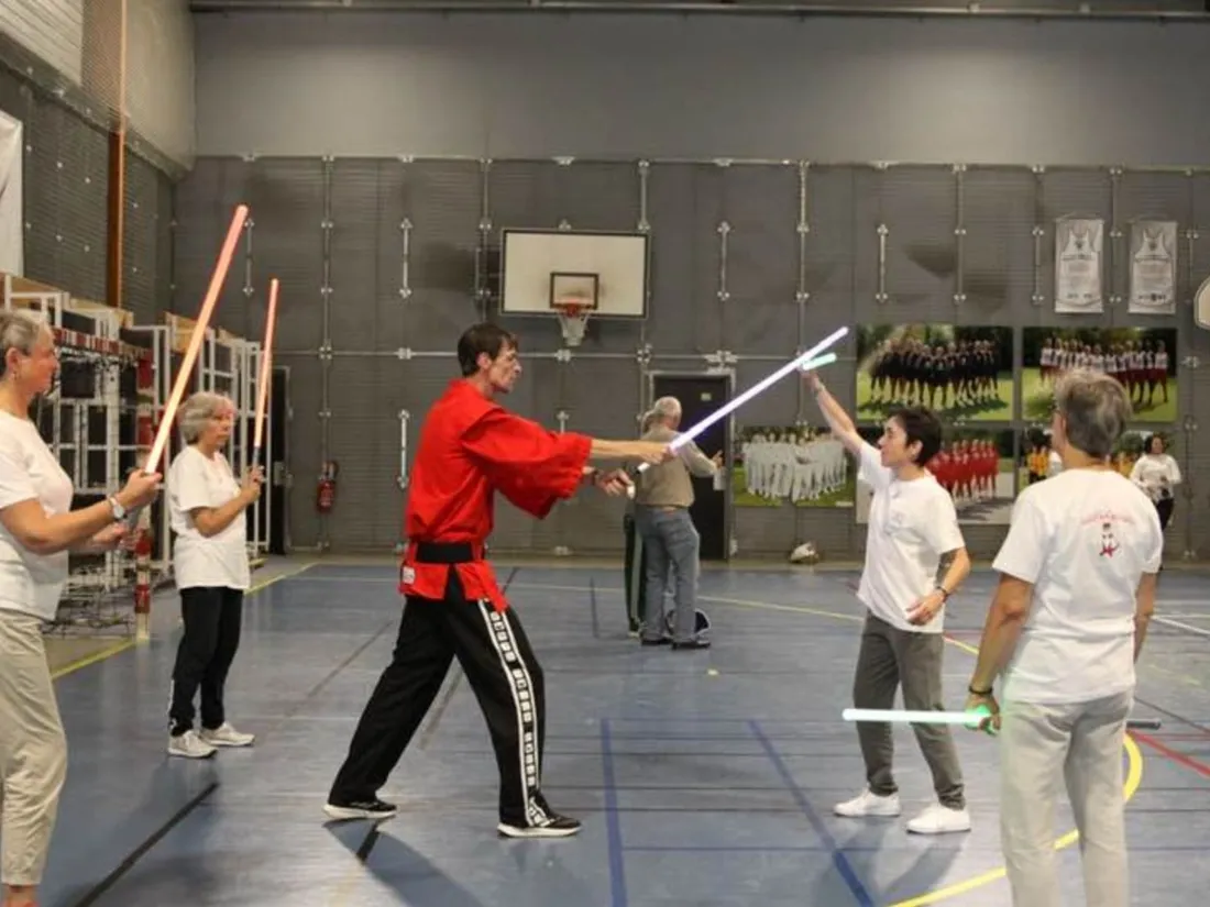 Un maître d'arme en plein cours de sabre laser avec des patientes 