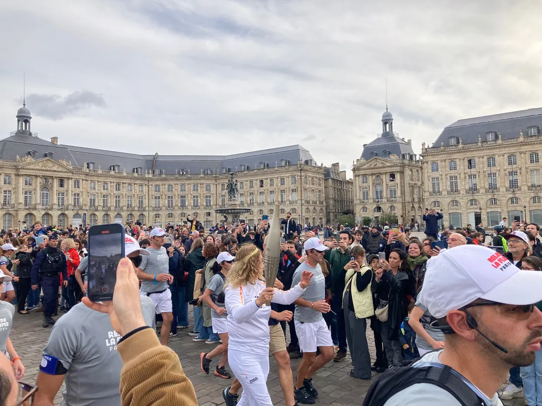 L'une des relayeuses de la flamme devant la Place de la Bourse