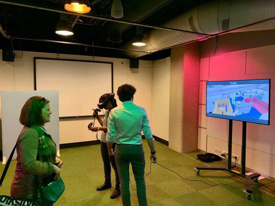 Une visiteuse expérimente un exercice de réalité virtuelle autour d'une expérience de laboratoire.