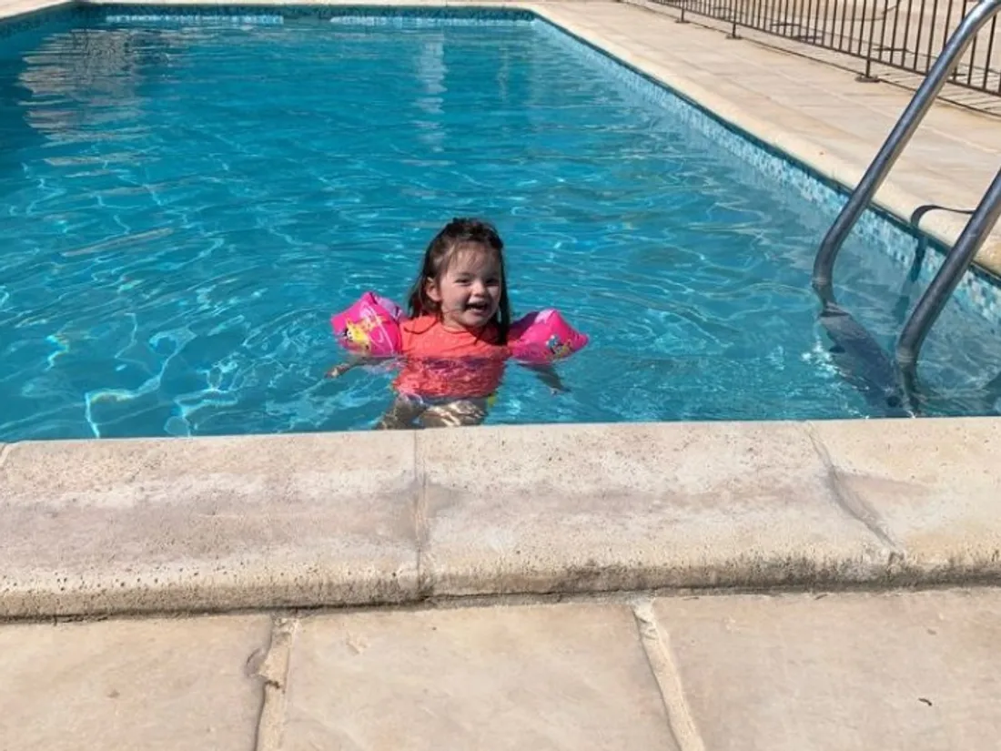 Une jeune fille qui nage dans une piscine