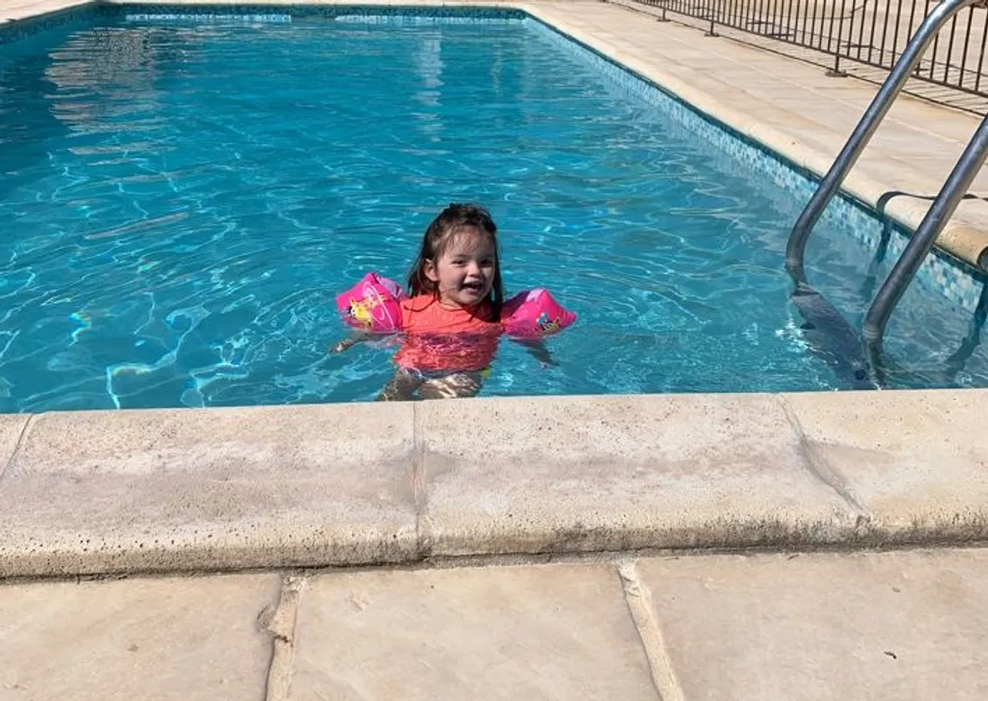 Une jeune fille qui nage dans une piscine