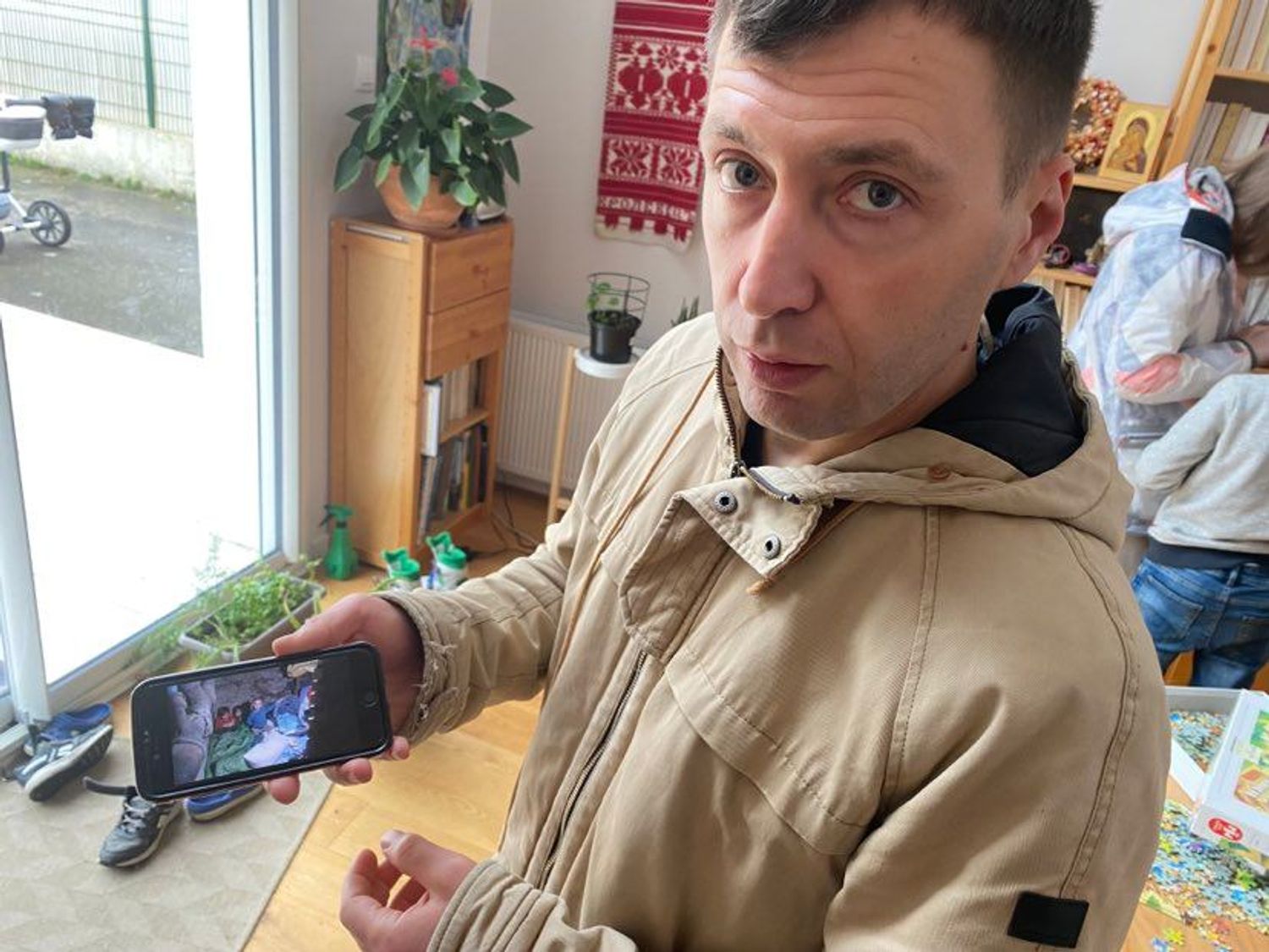 Ilia, père de famille ukrainien, montre des photos de ses amis réfugiés dans une cave
