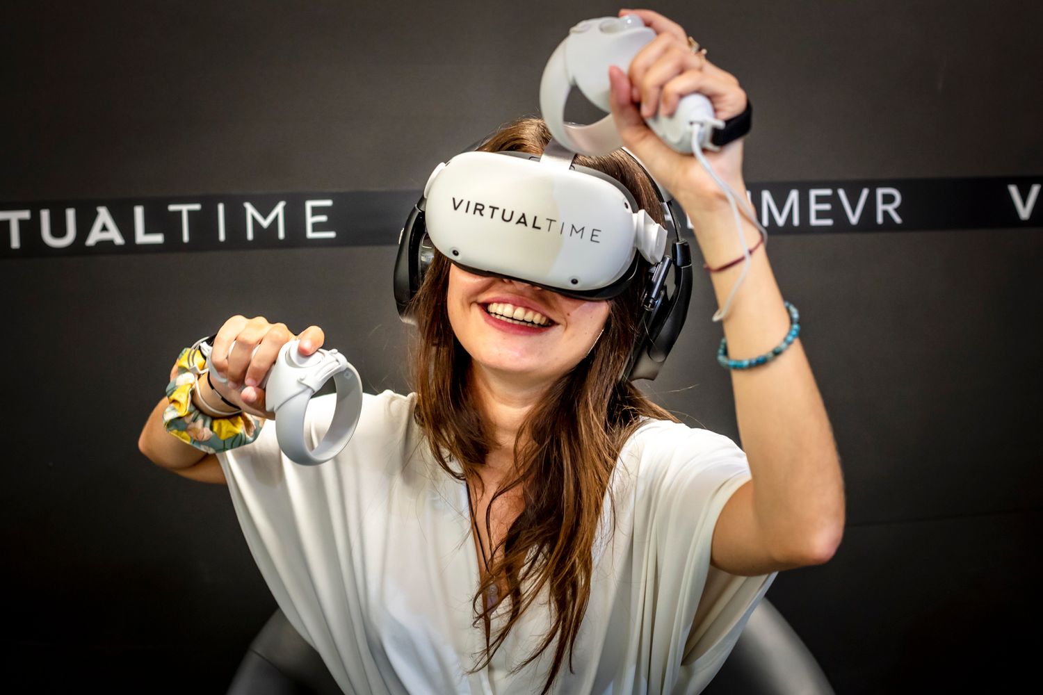 Une joueuse teste une expérience de tir à l'arc dans un box de Virtual time