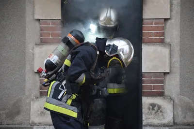 De la fumée s'échappe de la toiture d'un pavillon