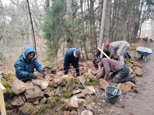 Un chantier participatif permet de restaurer un mur en pierre sèche...