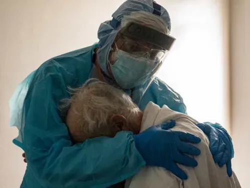 Une photo touchante d’un médecin enlaçant un patient âgé atteint du...